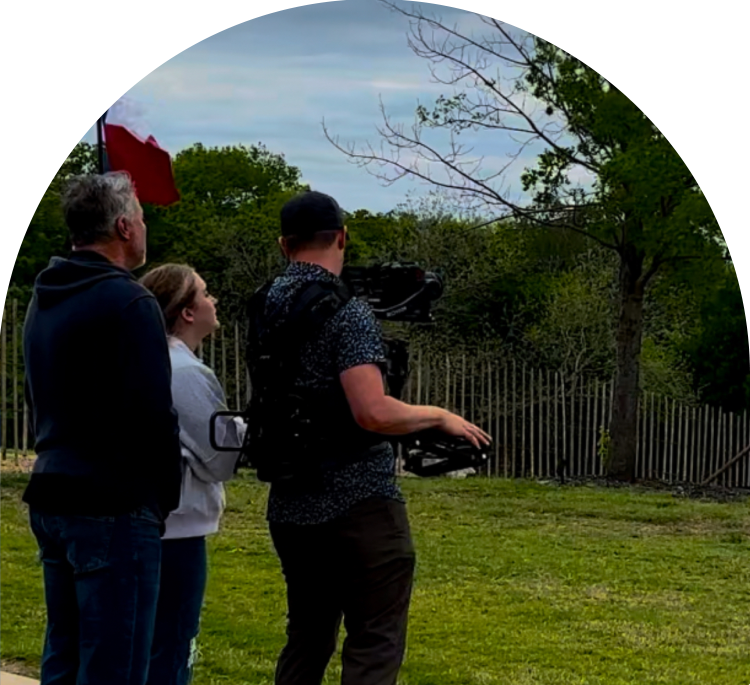 A group of people standing around in the grass.